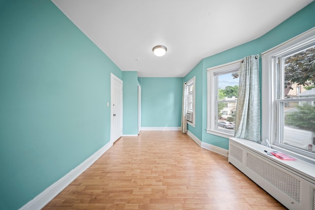 8564 79th St, Woodhaven, NY 11421 - spare room with radiator, light wood-style floors, and baseboards