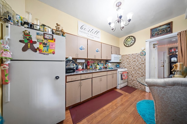 8564 79th St, Woodhaven, NY 11421 - kitchen with white appliances, light wood-type flooring, a chandelier, a sink, and dark countertops