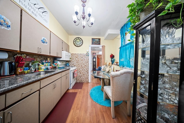 8564 79th St, Woodhaven, NY 11421 - kitchen with white appliances, a chandelier, light wood-style flooring, a sink, and dark countertops