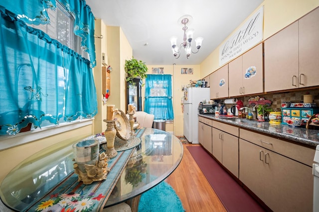 8564 79th St, Woodhaven, NY 11421 - kitchen featuring freestanding refrigerator, a sink, a chandelier, light wood-style floors, and dark countertops