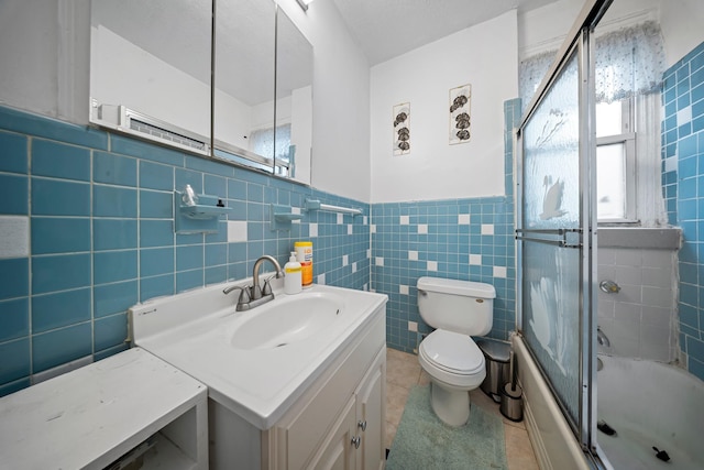 8564 79th St, Woodhaven, NY 11421 - bathroom featuring tile patterned floors, toilet, vanity, tile walls, and combined bath / shower with glass door