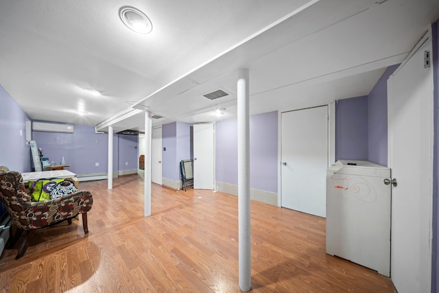 8564 79th St, Woodhaven, NY 11421 - finished below grade area with an AC wall unit, light wood finished floors, and baseboard heating
