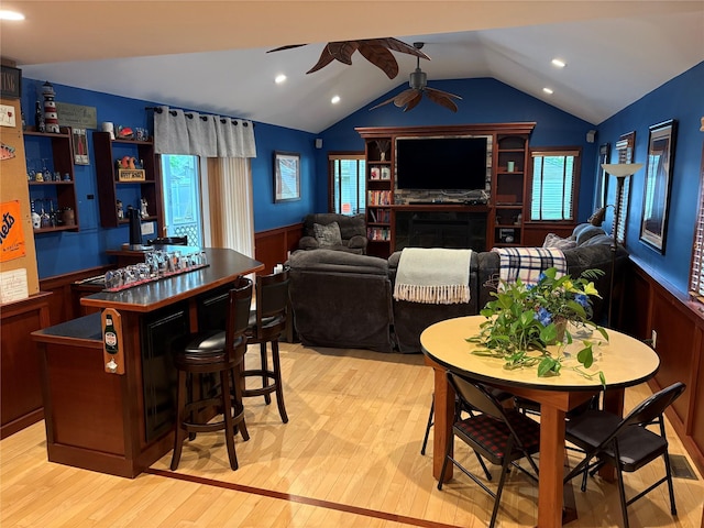 8 Sachs St, Bay Shore, NY 11706 - dining area with a ceiling fan, a dry bar, a wainscoted wall, light wood-style floors, and plenty of natural light