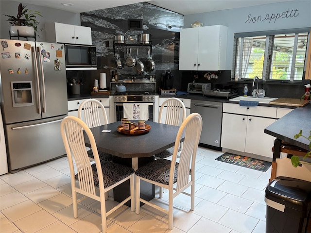 8 Sachs St, Bay Shore, NY 11706 - kitchen with stainless steel appliances, a sink, white cabinetry, tasteful backsplash, and dark countertops