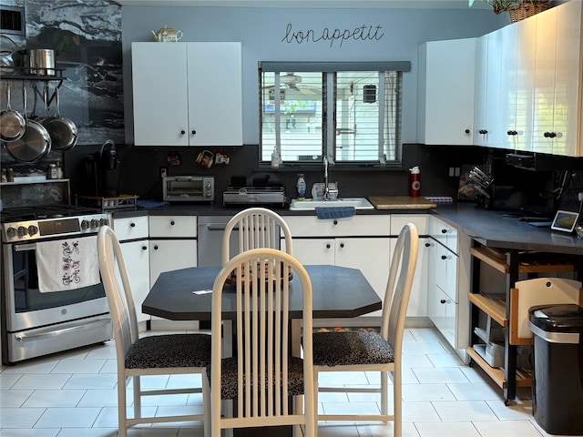 8 Sachs St, Bay Shore, NY 11706 - kitchen with stainless steel range with gas cooktop, a sink, white cabinets, and dark countertops