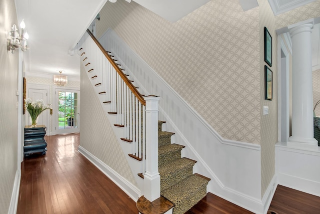7 Middle Dr, Manhasset, NY 11030 - staircase featuring wallpapered walls, a chandelier, hardwood / wood-style flooring, ornate columns, and ornamental molding
