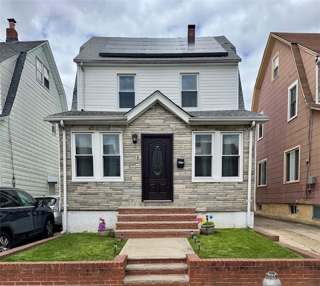 188-25 Mangin Ave, Jamaica, NY 11412 - view of front of property featuring entry steps, stone siding, and roof mounted solar panels