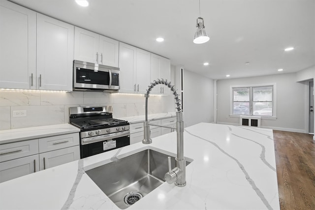 4163 Laconia Ave, Bronx, NY 10466 - kitchen featuring appliances with stainless steel finishes, recessed lighting, white cabinets, backsplash, and hanging light fixtures
