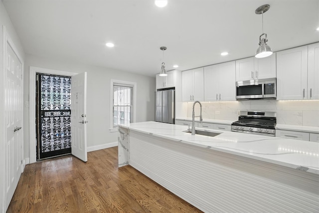 4163 Laconia Ave, Bronx, NY 10466 - kitchen featuring stainless steel appliances, a sink, backsplash, baseboards, and wood finished floors