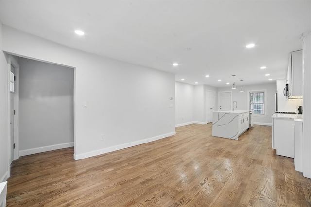 4163 Laconia Ave, Bronx, NY 10466 - unfurnished living room with recessed lighting, light wood-style flooring, baseboards, and a sink