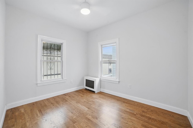 4163 Laconia Ave, Bronx, NY 10466 - empty room with wood finished floors, baseboards, and radiator