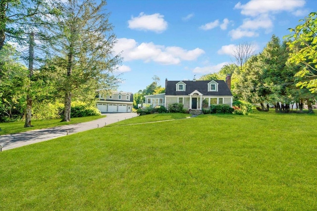 610 Farm To Market Rd, Brewster, NY 10509 - cape cod home featuring driveway, a front yard, a garage, and a chimney