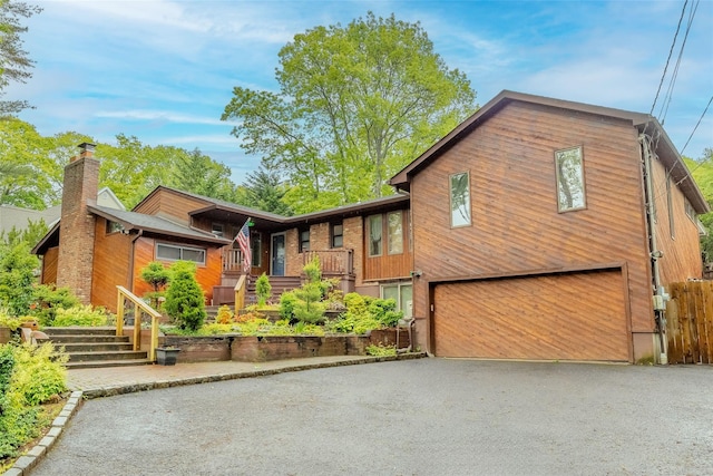 45 Broadview Dr, Commack, NY 11725 - view of front of property featuring an attached garage, asphalt driveway, a chimney, and stairs