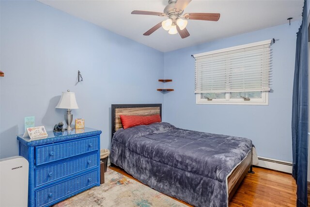 45 Broadview Dr, Commack, NY 11725 - bedroom featuring a baseboard radiator, wood finished floors, and a ceiling fan