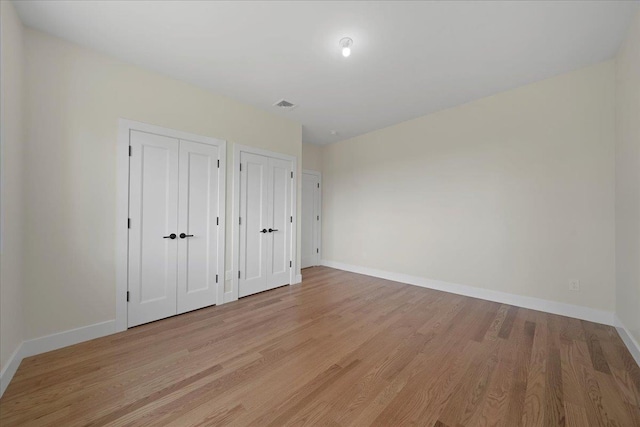 42 Greycourt Rd, Chester, NY 10918 - unfurnished bedroom featuring multiple closets, light wood finished floors, and baseboards