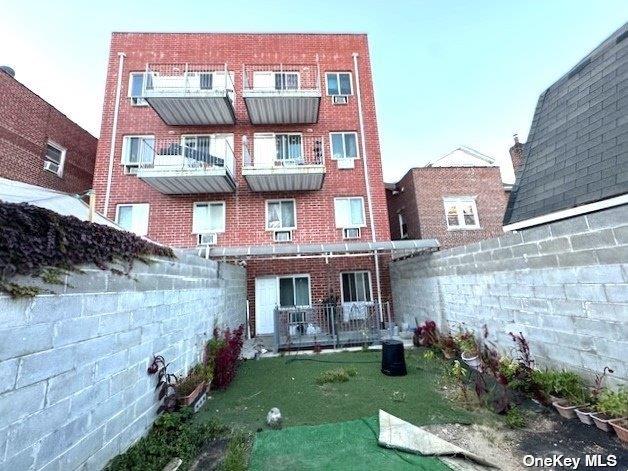 94-68 45th Ave, Elmhurst, NY 11373 - back of house featuring brick siding and a fenced backyard