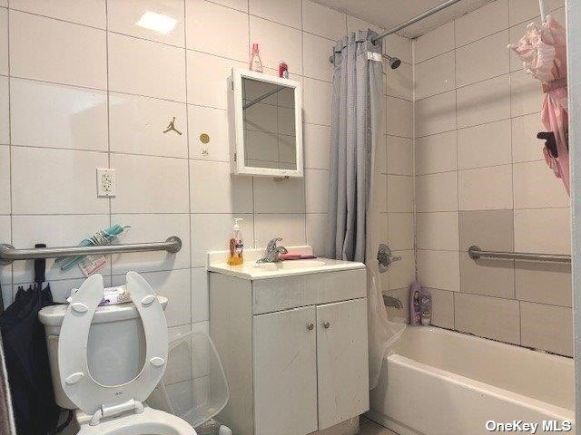 94-68 45th Ave, Elmhurst, NY 11373 - full bathroom featuring tile walls, shower / tub combo, vanity, and toilet