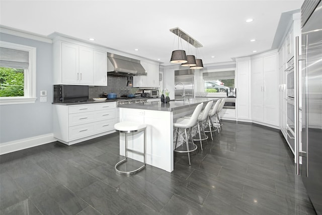 93 Haights Cross Rd, Chappaqua, NY 10514 - kitchen featuring wall chimney exhaust hood, plenty of natural light, a breakfast bar, baseboards, and recessed lighting