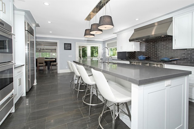 93 Haights Cross Rd, Chappaqua, NY 10514 - kitchen with wall chimney exhaust hood, crown molding, a sink, backsplash, and white cabinetry
