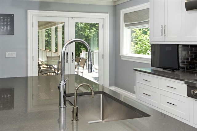 93 Haights Cross Rd, Chappaqua, NY 10514 - kitchen with a sink, white cabinetry, exhaust hood, crown molding, and tasteful backsplash