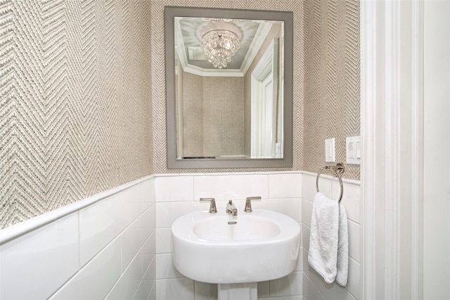 93 Haights Cross Rd, Chappaqua, NY 10514 - half bath featuring wallpapered walls, a chandelier, a wainscoted wall, tile walls, and a sink