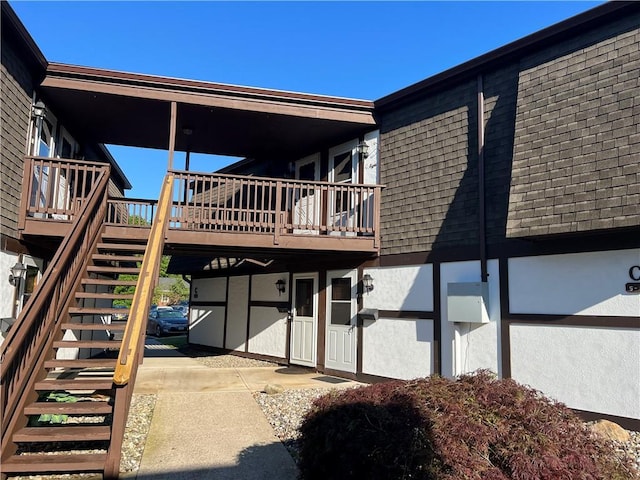 129 Main St Unit C8, Cornwall, NY 12518 - back of house with stairway, a shingled roof, and stucco siding