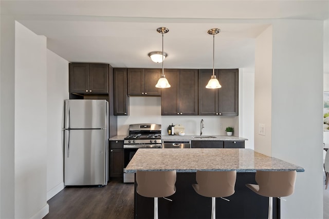 825 Morrison Ave Unit 5H, Bronx, NY 10473 - kitchen with appliances with stainless steel finishes, a sink, dark wood-style flooring, dark brown cabinets, and a breakfast bar area