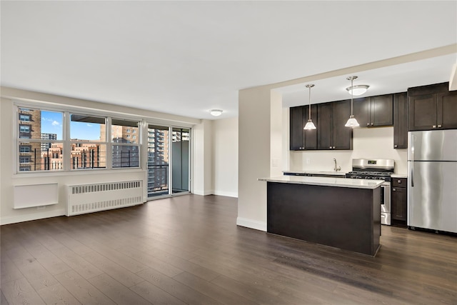 825 Morrison Ave Unit 5H, Bronx, NY 10473 - kitchen with stainless steel appliances, radiator, dark brown cabinetry, baseboards, and dark wood-type flooring
