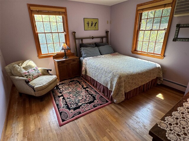 459 Illington Rd, Ossining, NY 10562 - bedroom with a baseboard radiator, wood finished floors, and a wall mounted AC