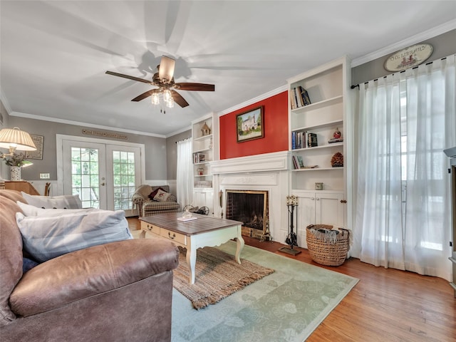 20 Tusten Ave, Goshen, NY 10924 - living area featuring light wood-type flooring, ornamental molding, ceiling fan, a fireplace with flush hearth, and built in shelves