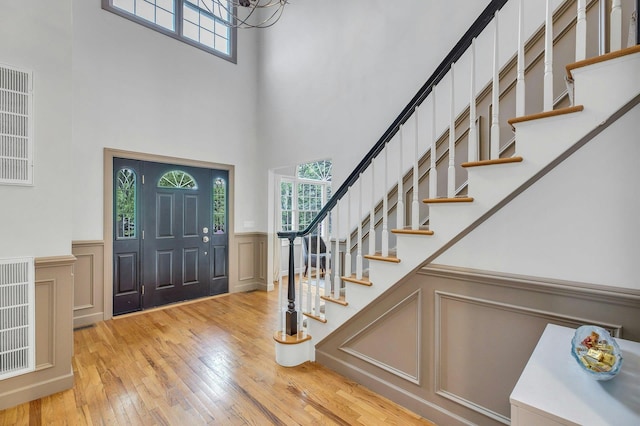 6 Esteves Ct, Melville, NY 11747 - entryway with a high ceiling, healthy amount of natural light, light wood-style floors, stairway, and a decorative wall