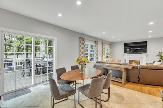 6 Esteves Ct, Melville, NY 11747 - dining area with recessed lighting, light tile patterned floors, and a warm lit fireplace