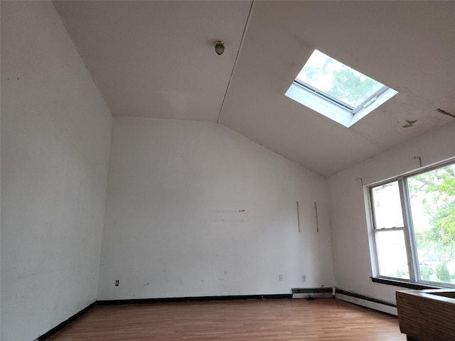 36 S 23rd St, Wyandanch, NY 11798 - unfurnished room featuring lofted ceiling, a skylight, light wood finished floors, and a baseboard heating unit