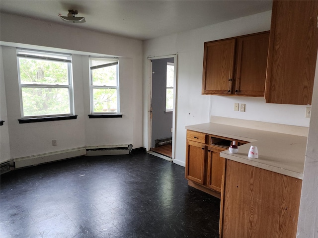 36 S 23rd St, Wyandanch, NY 11798 - kitchen with plenty of natural light, brown cabinetry, baseboard heating, and light countertops