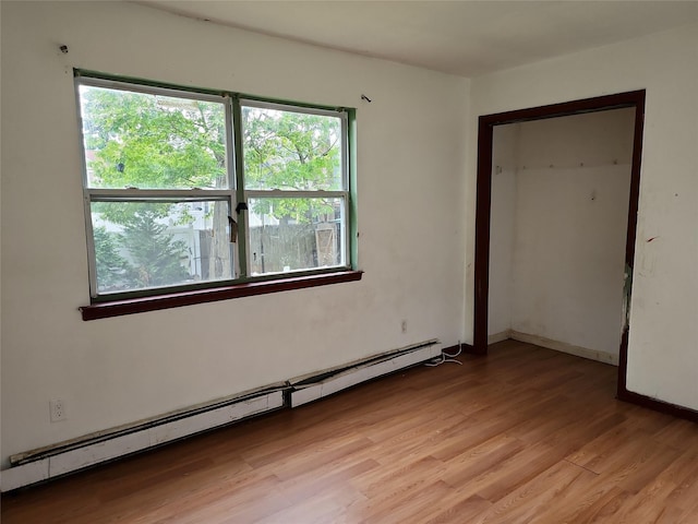 36 S 23rd St, Wyandanch, NY 11798 - empty room featuring a baseboard heating unit and light wood-style floors