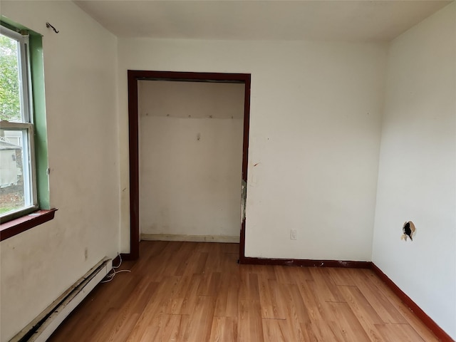 36 S 23rd St, Wyandanch, NY 11798 - spare room with a baseboard heating unit, light wood finished floors, and baseboards