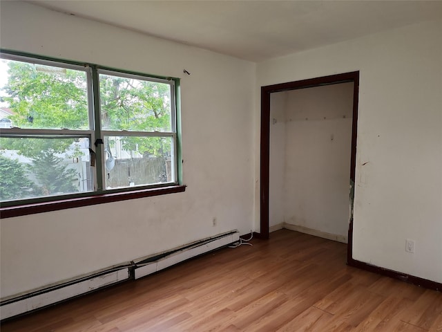 36 S 23rd St, Wyandanch, NY 11798 - empty room featuring a baseboard heating unit, light wood-style flooring, and baseboards