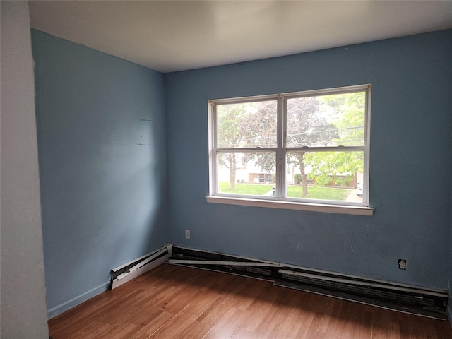 36 S 23rd St, Wyandanch, NY 11798 - empty room with healthy amount of natural light, wood finished floors, and a baseboard heating unit