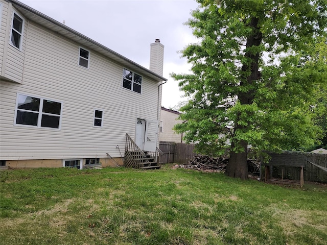 36 S 23rd St, Wyandanch, NY 11798 - rear view of house with a chimney and entry steps