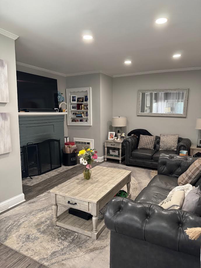 28 Brower Ave, Woodmere, NY 11598 - living area featuring ornamental molding, a glass covered fireplace, recessed lighting, and wood finished floors