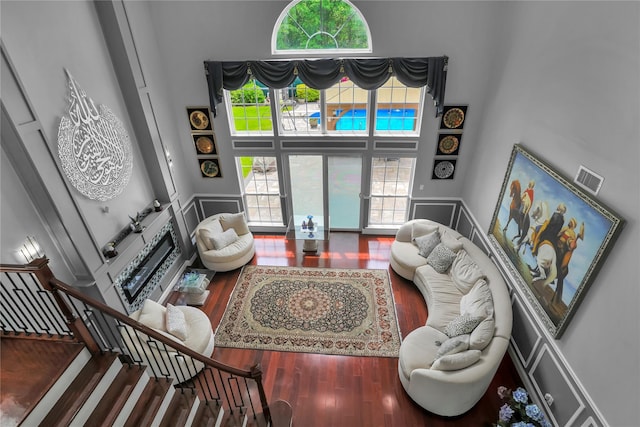 8 Wisteria Ln, Lake Grove, NY 11755 - living room featuring a high ceiling, wood finished floors, plenty of natural light, and stairway