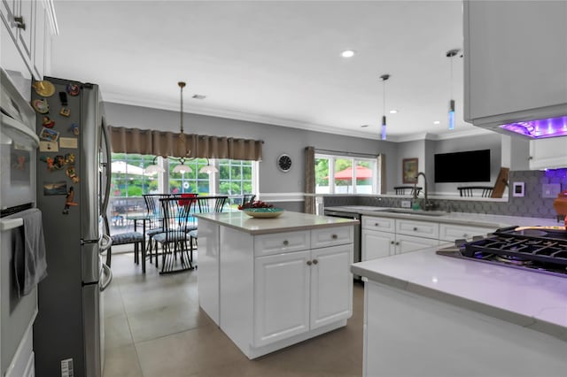 8 Wisteria Ln, Lake Grove, NY 11755 - kitchen featuring stainless steel appliances, a sink, ornamental molding, white cabinetry, and light countertops