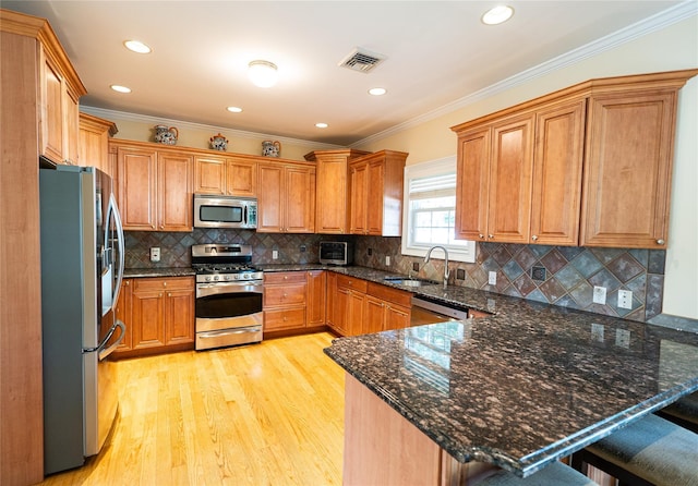 14 Gordon Ave, Plainview, NY 11803 - kitchen with stainless steel appliances, a sink, a peninsula, light wood finished floors, and crown molding