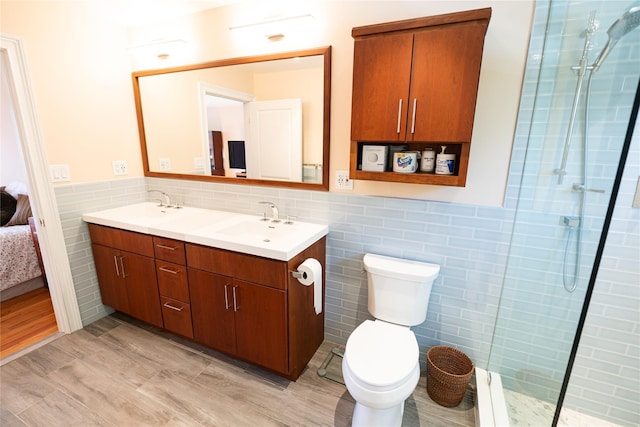 14 Gordon Ave, Plainview, NY 11803 - ensuite bathroom featuring tile walls, double vanity, tiled shower, a wainscoted wall, and toilet