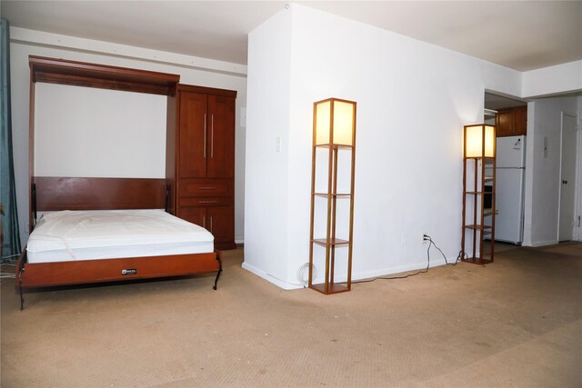 100 Randall Ave Unit 4J, Freeport, NY 11520 - bedroom with freestanding refrigerator, light carpet, and baseboards