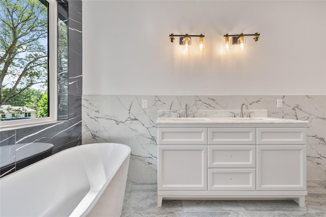615 Union Rd, Spring Valley, NY 10977 - bathroom with a freestanding tub, marble finish flooring, double vanity, wainscoting, and tile walls