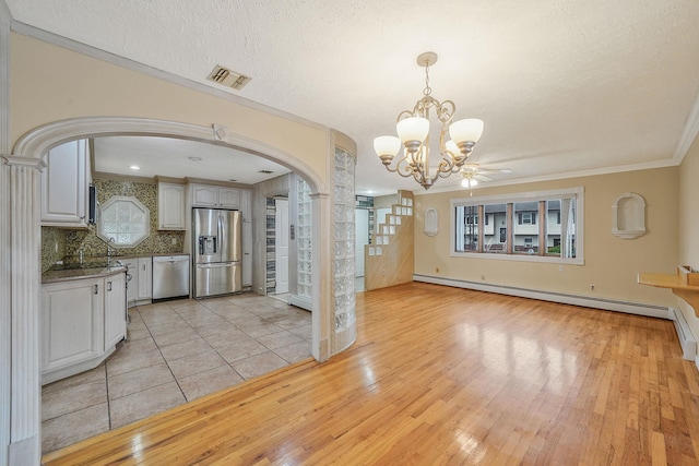 8 Adolphi Pl, Ronkonkoma, NY 11779 - kitchen with stainless steel appliances, arched walkways, a chandelier, light wood-style floors, and a baseboard heating unit