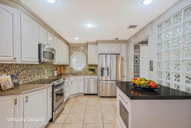 8 Adolphi Pl, Ronkonkoma, NY 11779 - kitchen featuring appliances with stainless steel finishes, dark countertops, a sink, light tile patterned flooring, and backsplash