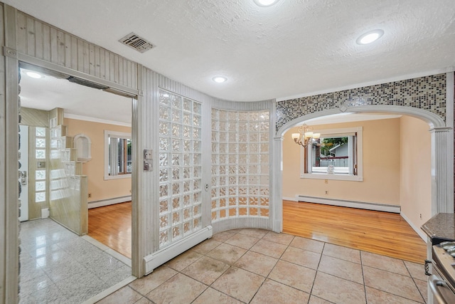 8 Adolphi Pl, Ronkonkoma, NY 11779 - empty room with a baseboard radiator, arched walkways, a textured ceiling, light tile patterned flooring, and a chandelier