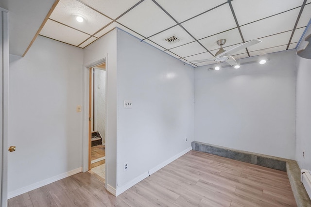 8 Adolphi Pl, Ronkonkoma, NY 11779 - basement with a baseboard heating unit, wood finished floors, a paneled ceiling, and baseboards